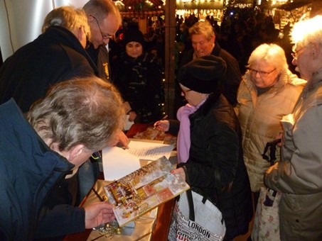 Bei der Gewinn-Ausgabestelle des Lions-Clubs Amberg am Weihnachtsmarkt bilden sich zeitweise Schlangen. Bild: Uschald